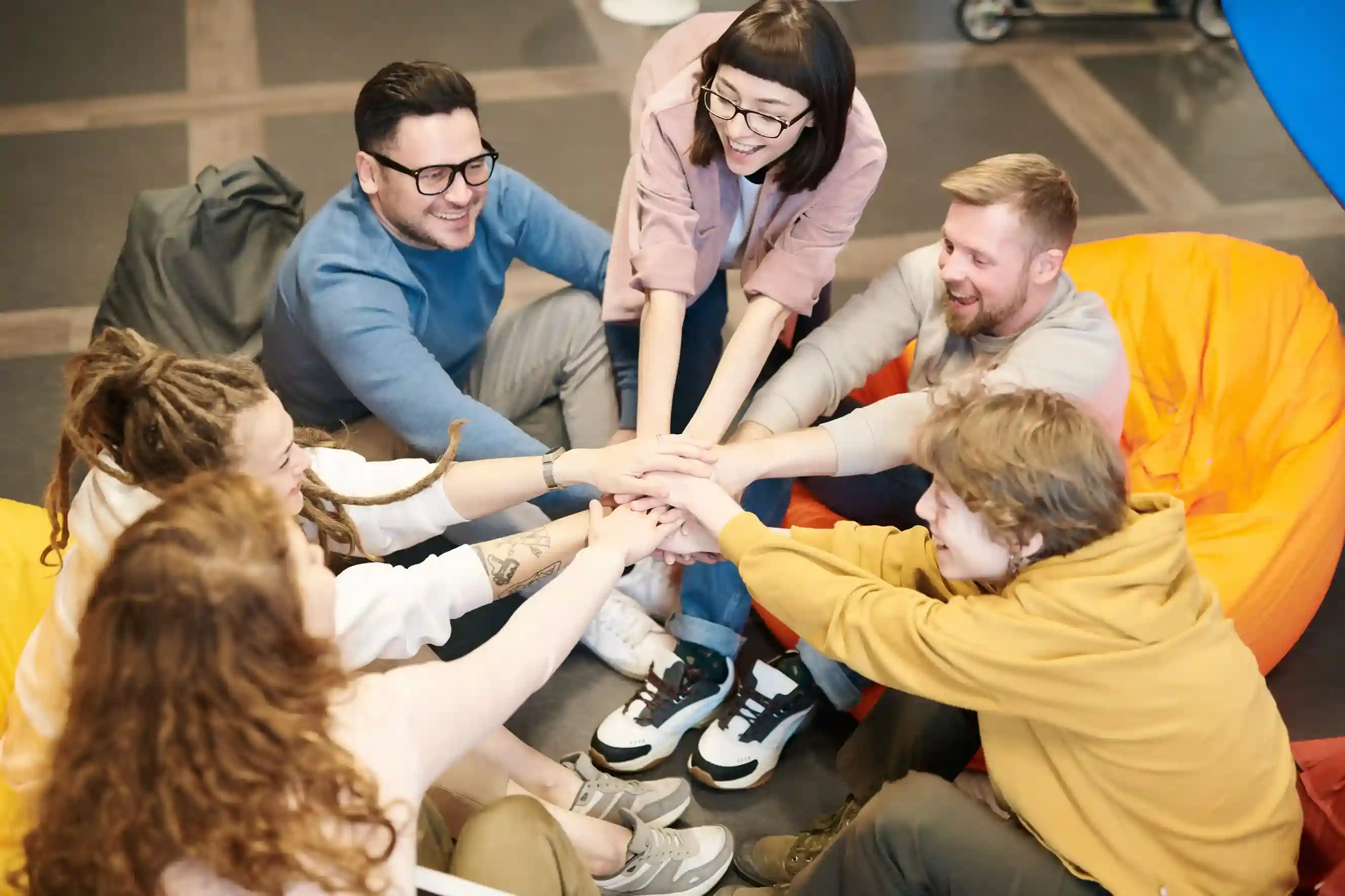 A team of professionals joining hands together in a collaborative workplace